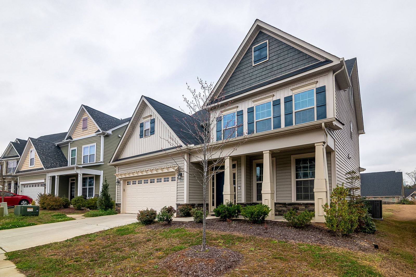 Row of newer craftsman-style houses with porches and garages