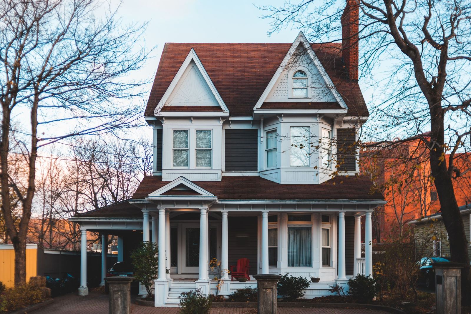 Victorian house with a red roof, twin gables and a columned porch
